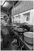 Man frying food in large pan. George Town, Penang, Malaysia ( black and white)