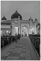 Men walking out of Masjid Kapitan Keling at dawn. George Town, Penang, Malaysia (black and white)