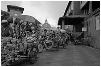 Trishaws leaving Town Square and Stadthuys. Malacca City, Malaysia (black and white)
