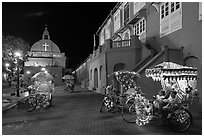Illuminated trishaws on Town Square at night. Malacca City, Malaysia ( black and white)