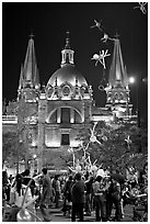 Children play with inflated balloons behind the Cathedral by night. Guadalajara, Jalisco, Mexico (black and white)