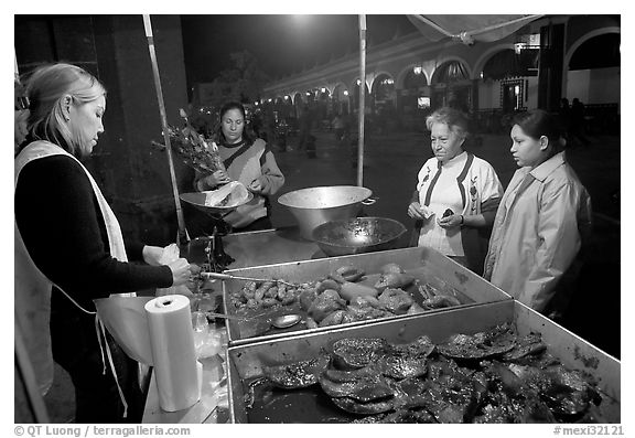 Women buying food at a food stand by night, Tlaquepaque. Jalisco, Mexico (black and white)