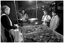Women buying food at a food stand by night, Tlaquepaque. Jalisco, Mexico ( black and white)