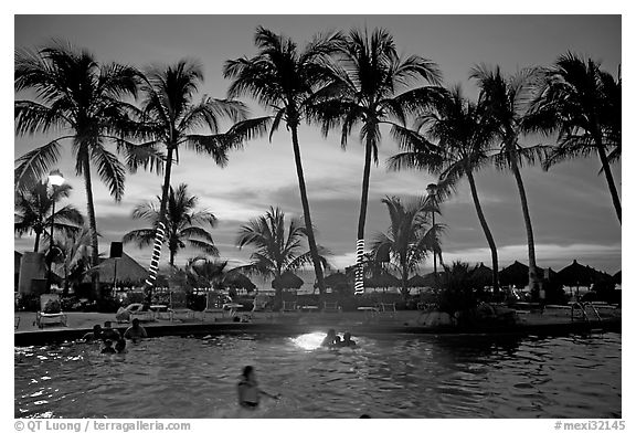 Palm-tree fringed swimming pool at sunset, Nuevo Vallarta, Nayarit. Jalisco, Mexico (black and white)