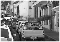 Young women riding in the back of a pick-up truck in a busy street, Puerto Vallarta, Jalisco. Jalisco, Mexico ( black and white)
