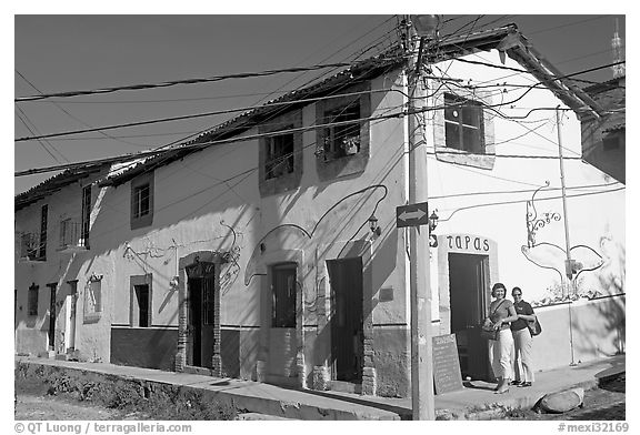 Two women outside of corner house with colorful door and window outlines, Puerto Vallarta, Jalisco. Jalisco, Mexico (black and white)