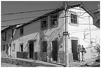 Two women outside of corner house with colorful door and window outlines, Puerto Vallarta, Jalisco. Jalisco, Mexico ( black and white)