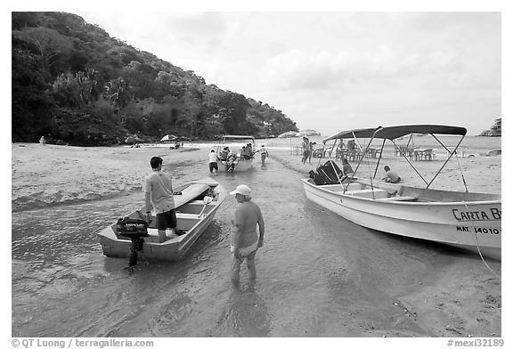 Boats moving from lagoon to ocean via small channel,  Boca de Tomatlan, Jalisco. Jalisco, Mexico (black and white)