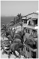 White adobe building with red tile roof,  palm trees and ocean, Puerto Vallarta, Jalisco. Jalisco, Mexico ( black and white)