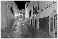 Uphill paved street by night with light trail. Zacatecas, Mexico ( black and white)