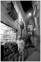 Man at a Newstand booth in a narrow callejone at night. Guanajuato, Mexico ( black and white)