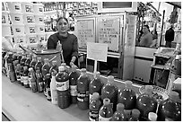 Woman at a booth with lots of chili bottles in Mercado Hidalgo. Guanajuato, Mexico ( black and white)