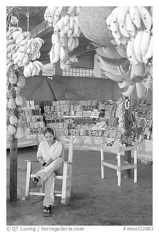 Woman sitting in a fruit stand. Mexico (black and white)