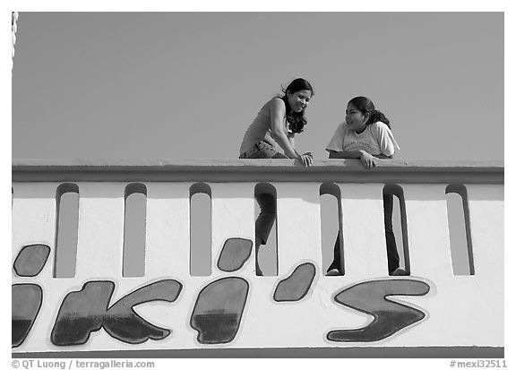 Young women sitting on a roof. Mexico (black and white)