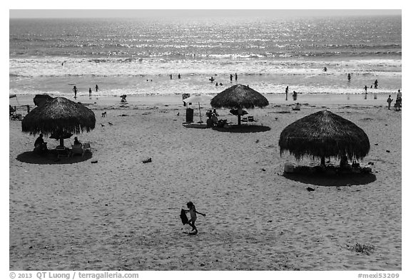 Straw sun shelter umbrellas and ocean, Ensenada. Baja California, Mexico