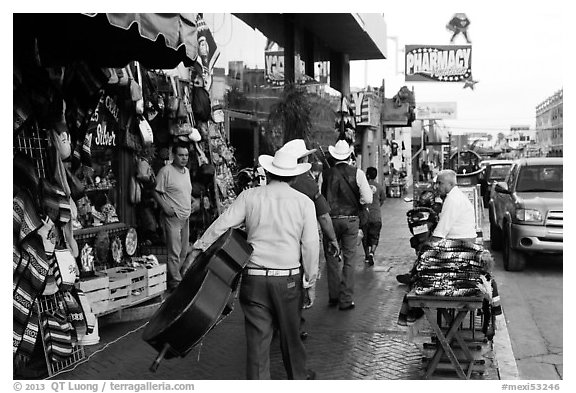 Musicians walking on street, Ensenada. Baja California, Mexico (black and white)