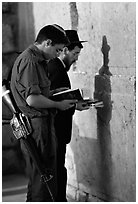 Young soldier and orthodox jew reading prayer  books at the Western Wall. Jerusalem, Israel (black and white)
