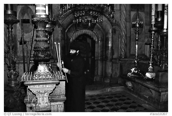 Christian Orthodox priest lighting candles. Jerusalem, Israel