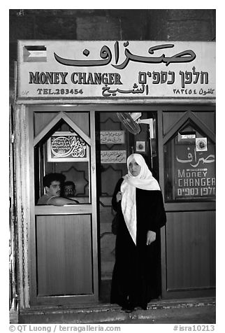 Muslem woman exiting a money changing booth. Jerusalem, Israel (black and white)