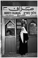 Muslem woman exiting a money changing booth. Jerusalem, Israel (black and white)