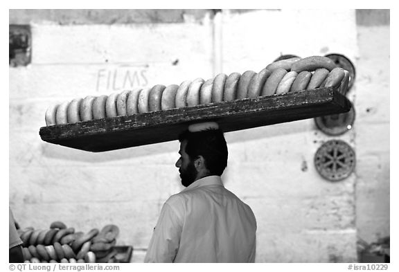 Man carrying many loafes of bread on his head. Jerusalem, Israel