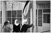 Women raise the Palestian flag at a school in East Jerusalem. Jerusalem, Israel ( black and white)