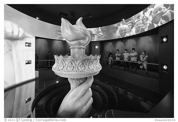 Visitors look at replica of Statue of Liberty torch, USA Pavilion. Expo 2020, Dubai, United Arab Emirates (black and white)