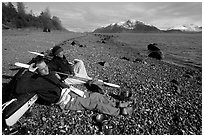 Kayakers relaxing on a beach between Rendu Inlet and Russel Island. Glacier Bay National Park, Alaska (black and white)