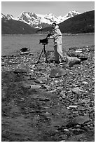 Large format photographer wearing kayaking gear on a beach in East Arm. Glacier Bay National Park, Alaska (black and white)