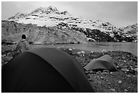 Park visitor looking, camp in front of Lamplugh Glacier. Glacier Bay National Park, Alaska (black and white)