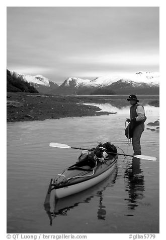 Kayaker standing in Scidmore Bay next to a shallow tidal channel. Glacier Bay National Park, Alaska