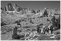Hikers on alpine terrain and Mt Giraud range, Dusy Basin. Kings Canyon National Park, California (black and white)