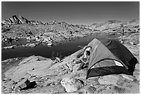 Man sitting in tent above lake, Dusy Basin. Kings Canyon National Park ( black and white)