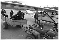 Unloading the gear from the plane to a trailer on the Port Alsworth airstrip. Lake Clark National Park, Alaska (black and white)