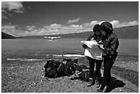 Backpackers orient themselves on the map while the plane is taking off. Lake Clark National Park, Alaska (black and white)