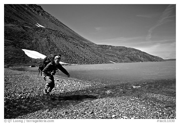 Jumping over a small stream next to Lake Turquoise. Lake Clark National Park, Alaska
