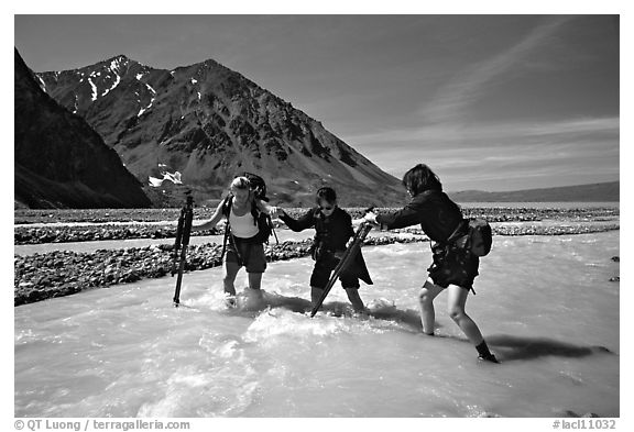 Hikers crossing a stream next to Lake Turquoise. Lake Clark National Park, Alaska