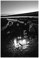Campers warming toes in campfire next to Turquoise Lake. Lake Clark National Park, Alaska (black and white)