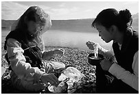 Backpackers eating noodles from a camp pot. Lake Clark National Park, Alaska (black and white)