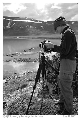Large format photographer with camera on the shores of Turquoise Lake. Lake Clark National Park, Alaska