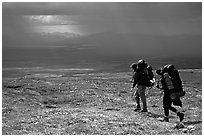 Two backpackers arrive at a ridge as a storm clears. Lake Clark National Park, Alaska (black and white)
