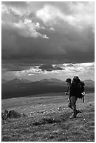 Backpacker seen from the side walking fast in the tundra. Lake Clark National Park, Alaska (black and white)