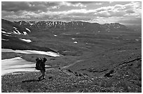 Backpackers walking down on a carpet of alpine flowers towards Twin Lakes. Lake Clark National Park, Alaska (black and white)