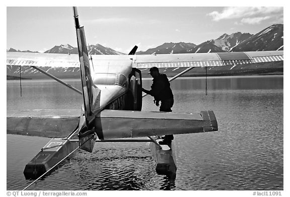 Pilot standing on floats of Floatplane, Twin Lakes. Lake Clark National Park, Alaska
