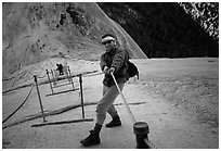 Hiker and cables on the regular route to Half-Dome. Yosemite National Park, California (black and white)