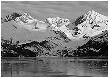 Coastal mountains with glacier dropping into icy fjord. Glacier Bay National Park, Alaska, USA. (black and white)