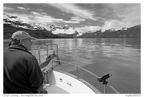 Man sitting at the bow of a small boat. Glacier Bay National Park, Alaska, USA.