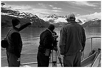 Crew filming from the deck of a boat. Glacier Bay National Park, Alaska, USA. (black and white)