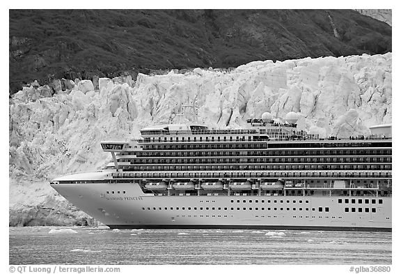 Cruise ship dwarfed by the face of Margerie Glacier. Glacier Bay National Park, Alaska, USA.