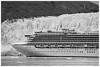 Cruise ship dwarfed by the face of Margerie Glacier. Glacier Bay National Park, Alaska, USA. (black and white)